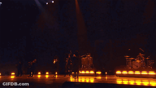 A Band Performing On Stage With A Sign That Says Fuerza Regida GIF