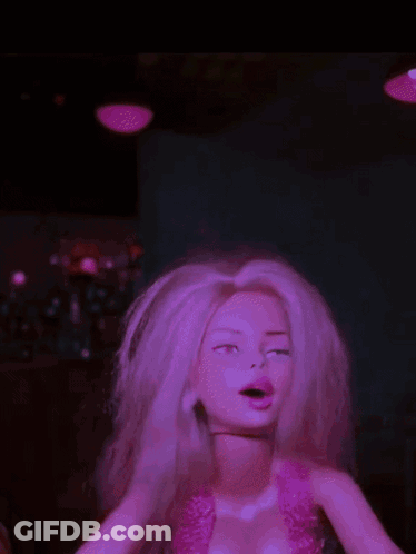 A Barbie Doll With Blonde Hair And A Pink Top GIF