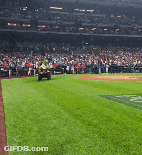 A Baseball Field With A Mascot On A Cart GIF