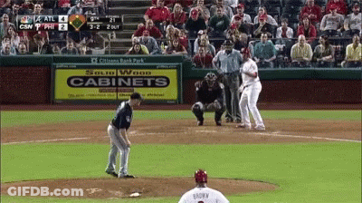 A Baseball Game Is Being Played In Front Of A Sign That Says Cabinets GIF