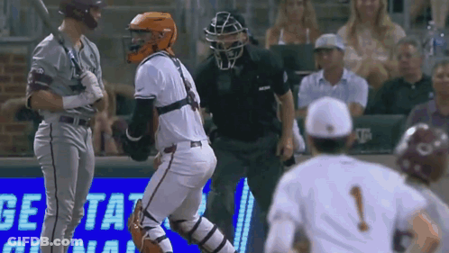 A Baseball Game Is Being Played In Front Of A Sign That Says Get Tat GIF