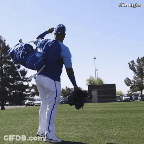 A Baseball Player Carrying A Duffel Bag With Kc On It GIF