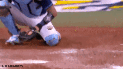 A Baseball Player Catching A Ball On A Field GIF