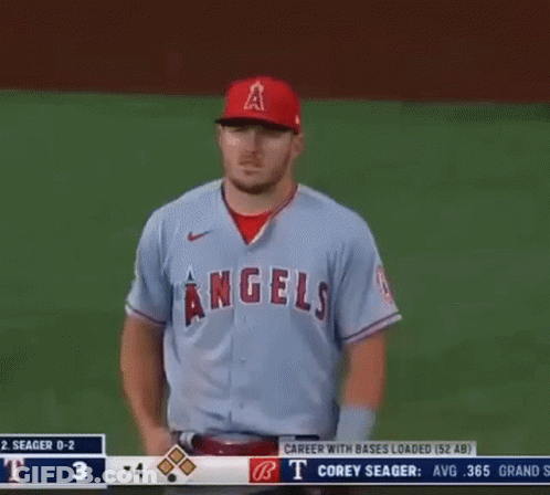 A Baseball Player For The Angels Is Standing On The Field With His Hands On His Hips GIF