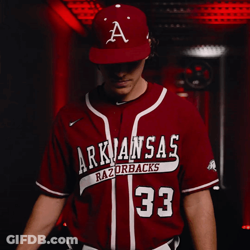 A Baseball Player For The Arkansas Razorbacks Looks At The Camera GIF