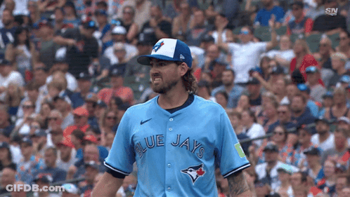 A Baseball Player For The Blue Jays Is Standing In Front Of A Crowd GIF