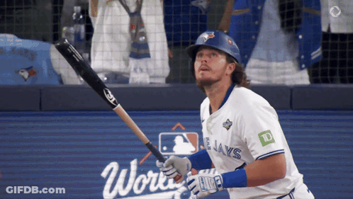 A Baseball Player For The Blue Jays Swings His Bat At The Ball GIF