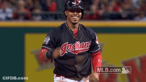 A Baseball Player For The Indians Is Running On The Field And Smiling . GIF