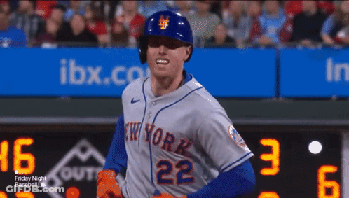 A Baseball Player For The New York Mets Is Standing In Front Of The Scoreboard GIF