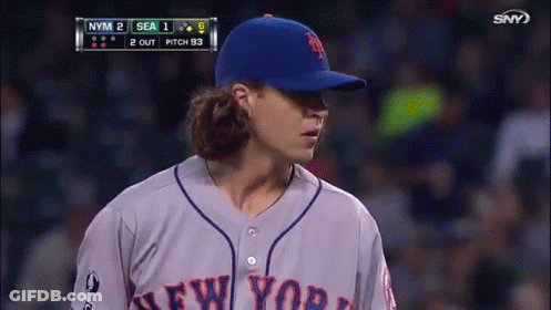 A Baseball Player For The New York Mets Stands In Front Of The Scoreboard GIF