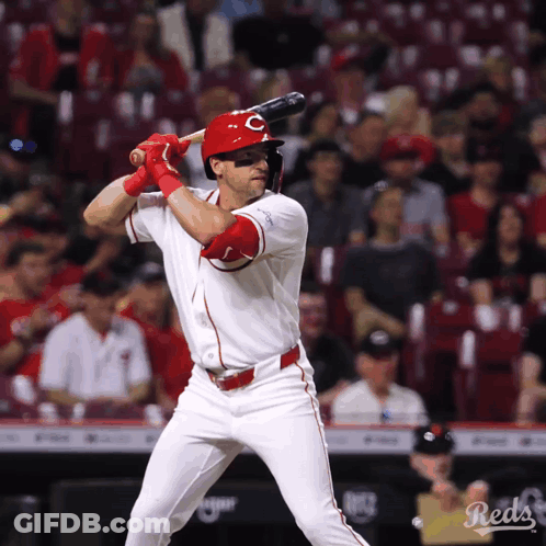 A Baseball Player For The Reds Is Swinging At A Ball GIF