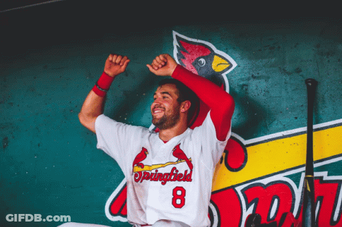 A Baseball Player For The Springfield Cardinals Is Sitting In A Dugout With His Arms In The Air GIF