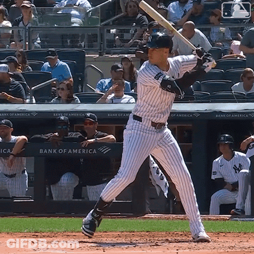 A Baseball Player Getting Ready To Bat In Front Of A Bank Of America Advertisement GIF