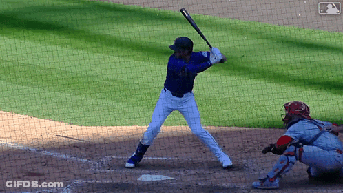 A Baseball Player Getting Ready To Hit The Ball With A MLB Logo In The Background GIF