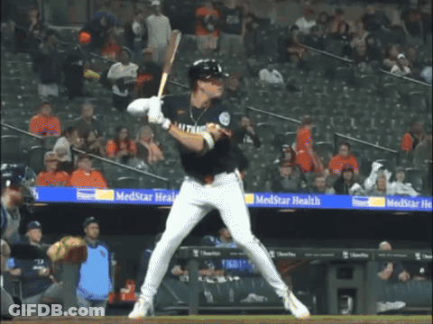 A Baseball Player Getting Ready To Swing At A Ball In Front Of A Banner For Medstar Health GIF