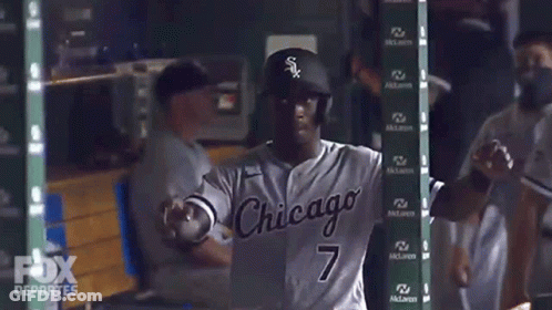 A Baseball Player In A Chicago Uniform Is Standing In The Dugout GIF