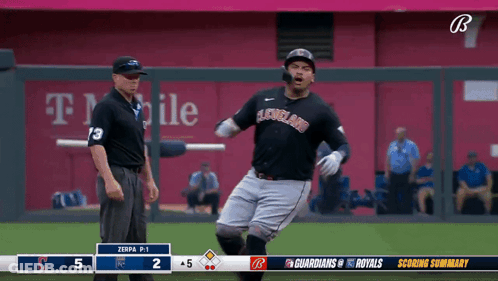 A Baseball Player In A Cleveland Uniform Is Running Towards A Referee GIF