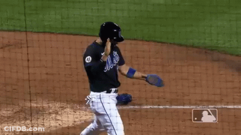 A Baseball Player In A Mets Uniform Is Standing On The Field . GIF