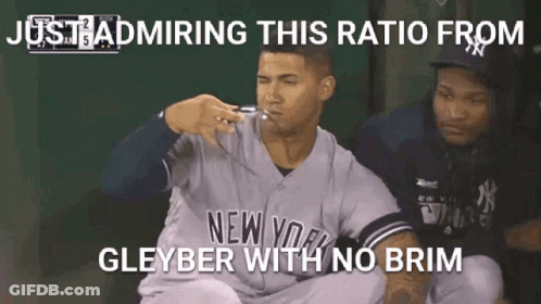 A Baseball Player In A New York Yankees Uniform Is Sitting In The Dugout With His Mouth Open . GIF