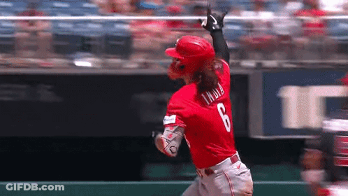 A Baseball Player In A Red Uniform Is Running Towards The Base . GIF