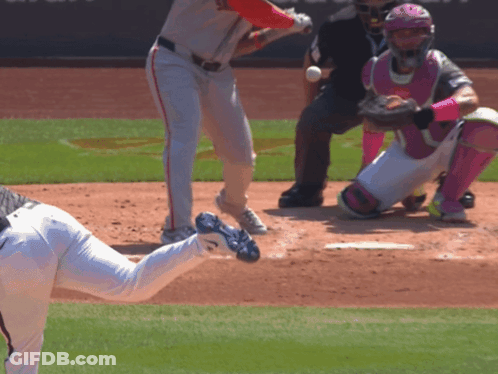 A Baseball Player In A White Jersey With A Red Hat Is About To Swing At A Ball GIF