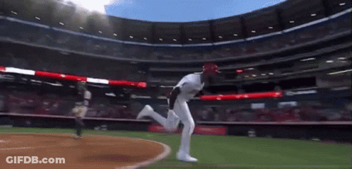 A Baseball Player In A White Uniform Is Running On A Field GIF
