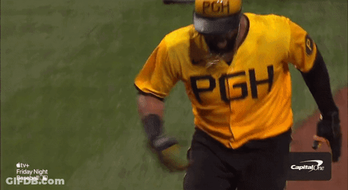 A Baseball Player In A Yellow Uniform Is Being Congratulated By A Group Of People GIF