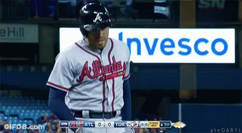 A Baseball Player In An Atlanta Braves Uniform Stands In Front Of A Sign For Invesco GIF