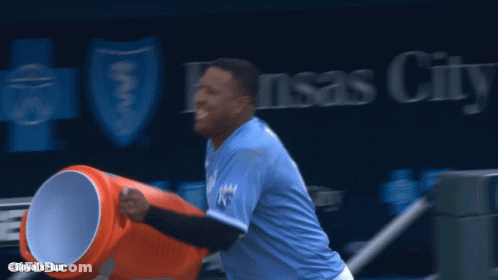 A Baseball Player In Front Of A Kansas City Advertisement GIF