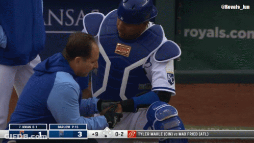 A Baseball Player Is Being Examined By A Doctor On The Field GIF
