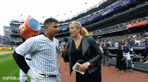 A Baseball Player Is Being Interviewed By A Woman With A Microphone In A Stadium With A Jbl Ad In The Background GIF