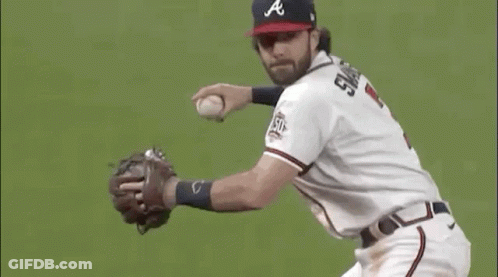 A Baseball Player Is Catching A Ball On A Field While Wearing A Hat And Glove . GIF