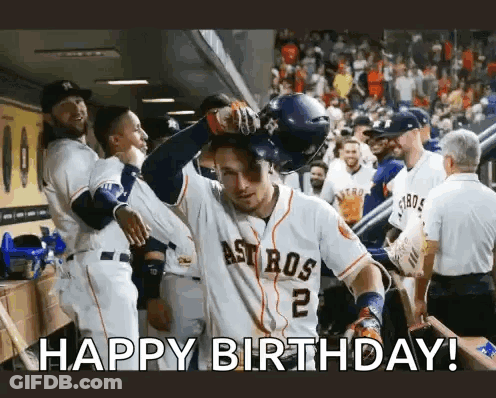 A Baseball Player Is Celebrating His Birthday In The Dugout While His Teammates Congratulate Him . GIF