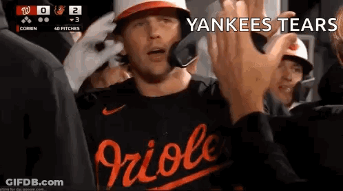 A Baseball Player Is Giving A High Five To A Fan While Wearing A Yankees Shirt . GIF