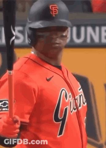 A Baseball Player Is Holding A Bat And Wearing An Orange Jersey That Says Giants GIF