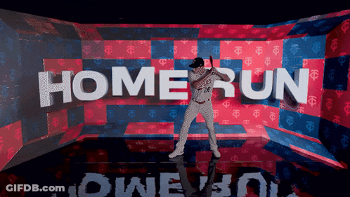 A Baseball Player Is Holding A Bat In Front Of A Wall That Says Home Run GIF