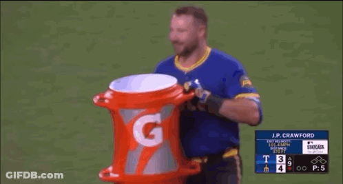 A Baseball Player Is Holding A Gatorade Bucket On The Field . GIF