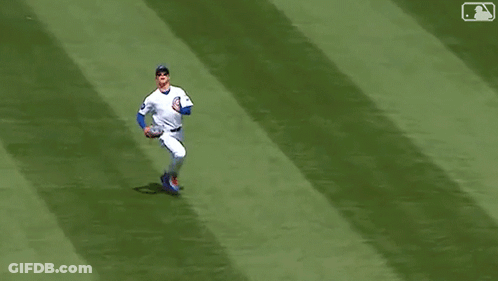 A Baseball Player Is Laying On The Field With His Feet Up . GIF