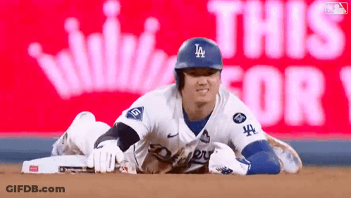 A Baseball Player Is Laying On The Ground In Front Of A Sign That Says This For 1 GIF