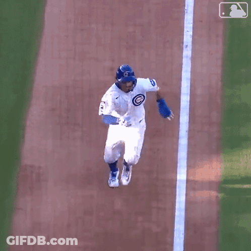 A Baseball Player Is Laying On The Ground On His Back . GIF