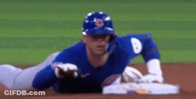 A Baseball Player Is Laying On The Ground On The Field GIF