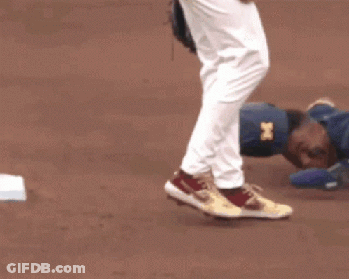 Baseball Player Laying On Ground With Catcher Watching GIF
