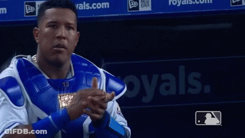 A Baseball Player Is Pointing At The Camera In Front Of A Royals Sign GIF