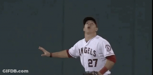 A Baseball Player Is Reaching Up To Catch A Ball In Front Of A Wall With The Number 400 On It . GIF