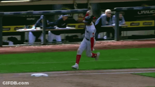 A Baseball Player Is Running On The Field With A Dugout In The Background That Says Corona GIF