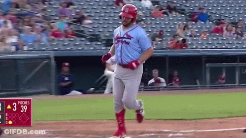 A Baseball Player Is Running To First Base During A Baseball Game . GIF