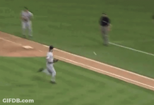 A Baseball Player Is Running Towards A Base While A Catcher Is Kneeling Down . GIF