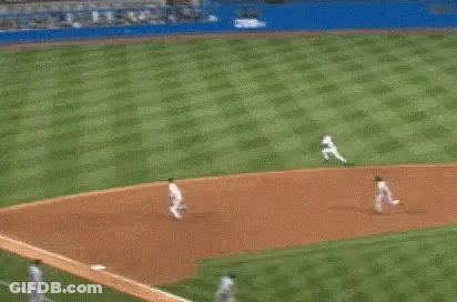 A Baseball Player Is Running Towards The Base While A Crowd Watches . GIF