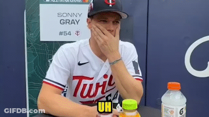 A Baseball Player Is Sitting At A Table With His Hand On His Face . GIF