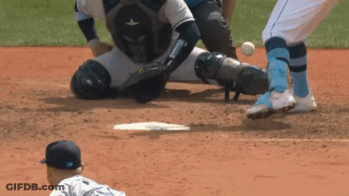 A Baseball Player Is Sliding Into Base While The Catcher Watches GIF